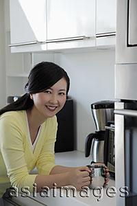 Asia Images Group - Woman resting on counter holding coffee cup