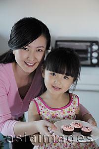 Asia Images Group - Mother and daughter holding a plate of cupcakes