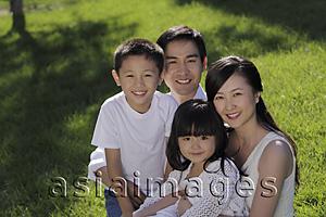 Asia Images Group - Young family sitting on the grass smiling