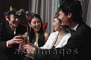 Asia Images Group - Two couples celebrating at a party, toasting each other