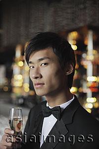 Asia Images Group - Head shot of man in a tuxedo holding a glass of champagne