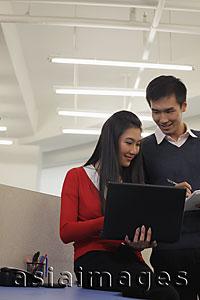 Asia Images Group - Young man and woman working together in an office
