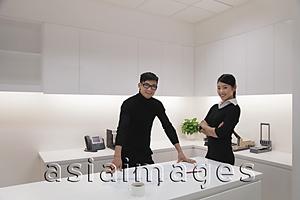 Asia Images Group - Young man and woman standing in modern office