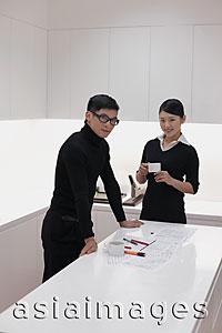 Asia Images Group - Man and woman dressed in black working in modern office