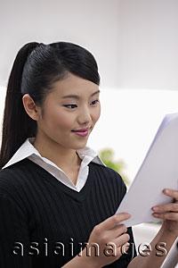 Asia Images Group - Head shot of young woman looking at paper