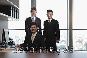 Asia Images Group - Three businessmen standing together in an office