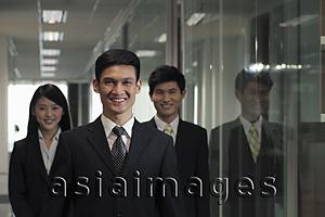 Asia Images Group - Three businesspeople standing in hallway