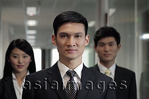 Asia Images Group - Three businesspeople standing in hallway