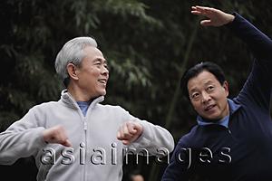 Asia Images Group - Two older gentlemen stretching together