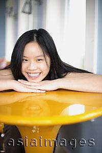 Asia Images Group - Young woman smiling and relaxing her head on her hands