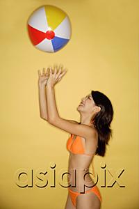 AsiaPix - Young woman in bikini, throwing ball in air