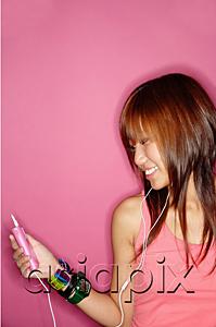 AsiaPix - Young woman looking at mp3 player