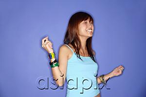 AsiaPix - Young woman against blue background, snapping fingers