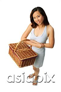 AsiaPix - Woman carrying picnic basket, looking at camera