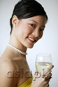 AsiaPix - Woman holding wine glass, smiling at camera, portrait