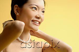 AsiaPix - Woman putting on pearl necklace