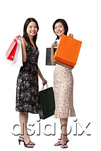AsiaPix - Two young women carrying shopping bags, looking at camera