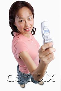 AsiaPix - Woman holding mobile phone up, looking at camera