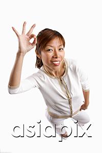 AsiaPix - Woman standing, looking at camera, making hand sign