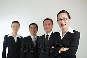 AsiaPix - Businesswoman with arms crossed, other executives in the background, smiling