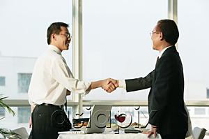 AsiaPix - Businessmen shaking hands over lunch table
