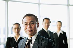 AsiaPix - Businessman looking at camera, people in the background