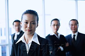 AsiaPix - Businesswoman looking at camera, people in the background