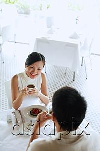 AsiaPix - Woman and man at cafe, woman holding cup of coffee, high angle view