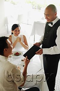 AsiaPix - Couple in restaurant, man handing menu back to waiter