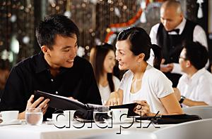 AsiaPix - Couple in restaurant, holding menu and smiling at each other