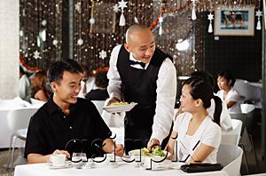 AsiaPix - Waiter serving couple at restaurant