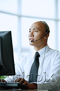 AsiaPix - Man with headset, using computer