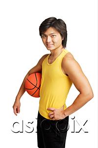 AsiaPix - Man with basketball under arm, hand on hip, looking at camera
