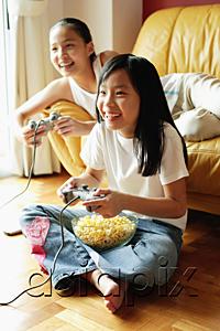 AsiaPix - Two sisters in living room, playing video games