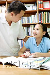 AsiaPix - Father and daughter looking at each other, books open on desk in front of them