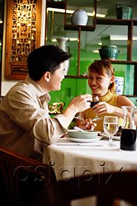 AsiaPix - Couple toasting with wine glasses in restaurant