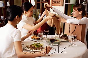 AsiaPix - Women in restaurant, one woman showing clothing item to the others