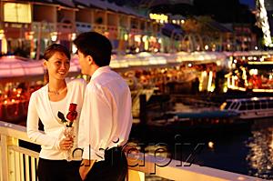 AsiaPix - Couple standing next to railing, woman holding rose