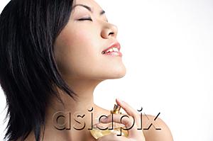 AsiaPix - Woman holding perfume bottle