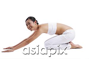 AsiaPix - Woman kneeling on floor stretching
