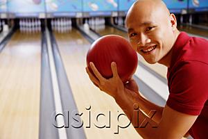 AsiaPix - Man holding bowling ball, smiling at camera