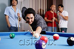 AsiaPix - Man aiming pool cue at ball, other men watching in the background