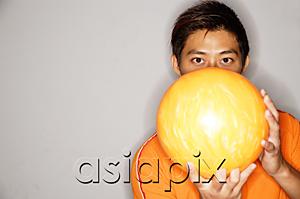 AsiaPix - Man holding bowling ball in front of face