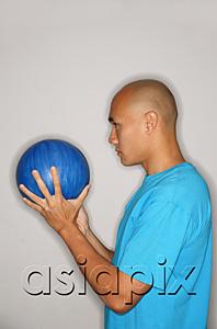 AsiaPix - Man holding bowling ball looking away