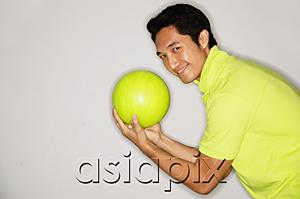 AsiaPix - Man holding bowling ball, turning to smile at camera