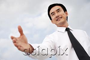 AsiaPix - Businessman with hand outstretched, low angle view