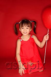 AsiaPix - Girl holding heart shaped balloon, kneeling on floor
