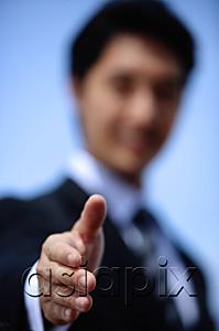 AsiaPix - Businessman offering hand for handshake, selective focus