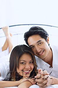 AsiaPix - Couple side by side on bed, smiling, portrait