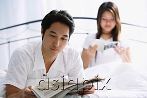 AsiaPix - Couple on bed, man reading newspaper, woman behind him reading book